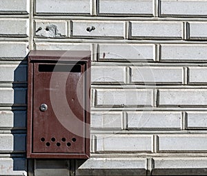 Old mail box hanging on the white brick wall
