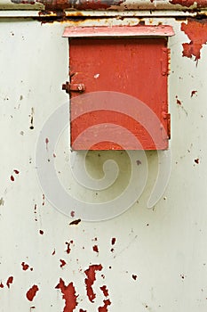 Old mailbox with the door peeling paint.