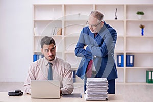 Old male boss and young male employee in bullying concept