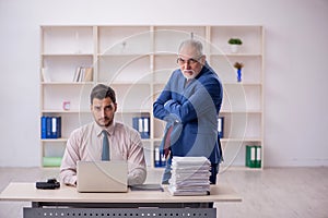 Old male boss and young male employee in bullying concept