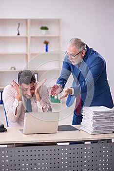 Old male boss and young male employee in bullying concept