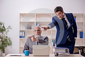 Old male boss and young male employee in the office