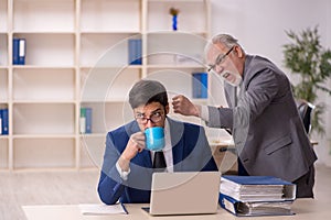 Old male boss and young male employee in the office