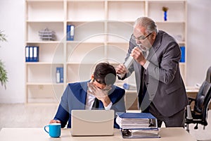 Old male boss and young male employee in the office