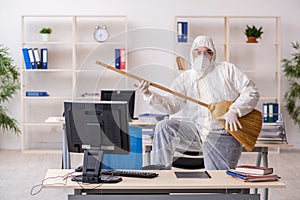 Old male contractor cleaning the office holding broom