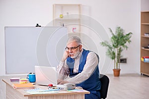 Old male designer working in the office