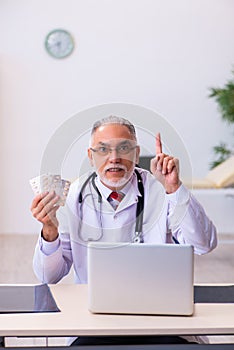 Old male doctor holding pills