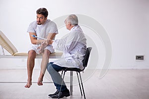 Old male doctor psychiatrist examining young male patient