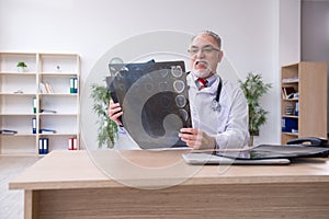 Old male doctor radiologist working in the clinic