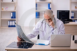 Old male doctor radiologist working in the clinic