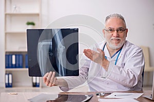 Old male doctor radiologist working in the clinic