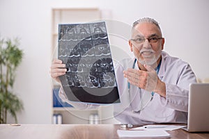 Old male doctor radiologist working in the clinic