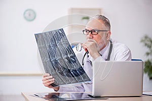 Old male doctor radiologist working in the clinic