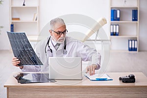 Old male doctor radiologist working in the clinic