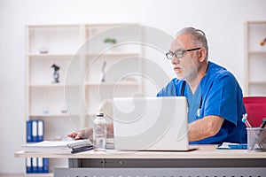 Old male doctor radiologist working in the clinic