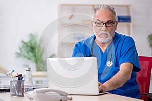 Old male doctor in telemedicine concept