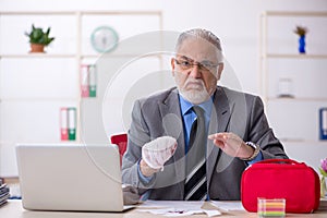 Old male employee cutting his hand in the office