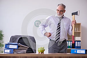 Old male employee holding hatchet in budget planning concept
