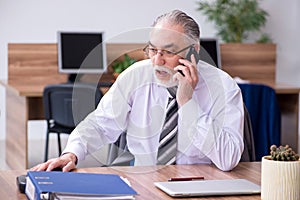 Old male employee suffering from radiculitis at workplace