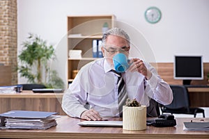 Old male employee suffering from radiculitis at workplace