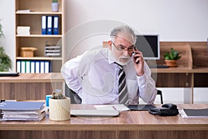 Old male employee suffering from radiculitis at workplace