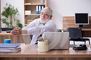 Old male employee suffering from radiculitis at workplace