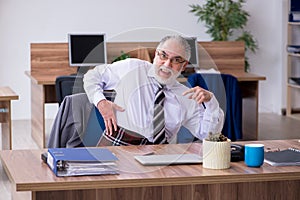 Old male employee suffering from radiculitis at workplace