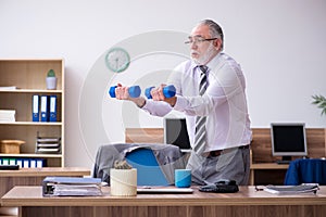 Old male employee suffering from radiculitis at workplace