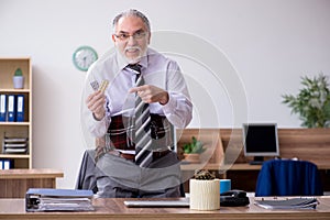 Old male employee suffering from radiculitis at workplace