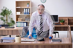 Old male employee suffering from radiculitis at workplace