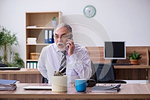 Old male employee suffering from radiculitis at workplace