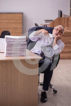 Old male employee in time manegement concept photo