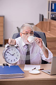 Old male employee in time manegement concept photo