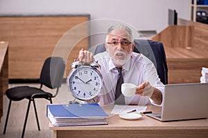 Old male employee in time manegement concept photo