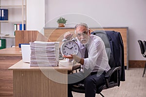 Old male employee in time manegement concept