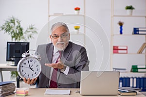 Old male employee in time mangement concept