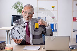 Old male employee in time mangement concept