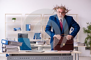 Old male employee wearing prickly wreath on head