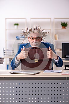 Old male employee wearing prickly wreath on head