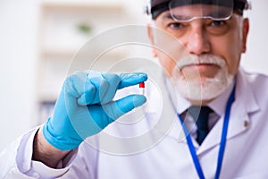 Old male expert criminologist working in the lab for evidence