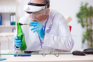 Old male expert criminologist working in the lab for evidence