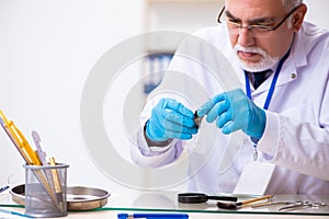 Old male expert criminologist working in the lab for evidence