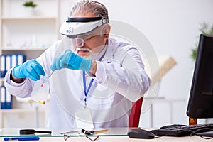 Old male expert criminologist working in the lab for evidence