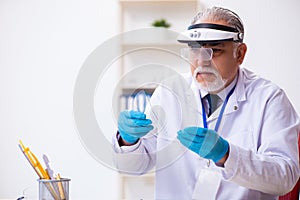 Old male expert criminologist working in the lab for evidence