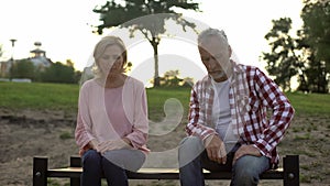 Old male and female sitting on bench, sad man thinking about incurable disease