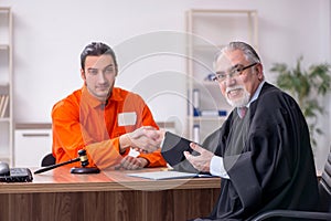 Old male judge meeting with young captive in courthouse