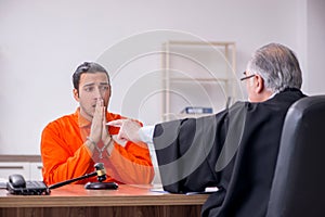 Old male judge meeting with young captive in courthouse