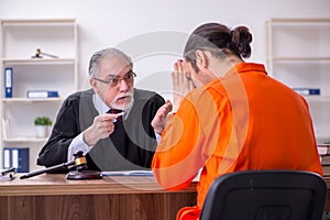 Old male judge meeting with young captive in courthouse