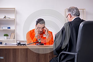 Old male judge meeting with young captive in courthouse