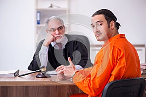 Old male judge meeting with young captive in courthouse